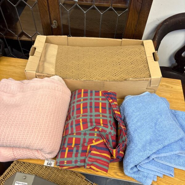 Box of mixed blankets and throws including pink, chequered and blue textiles