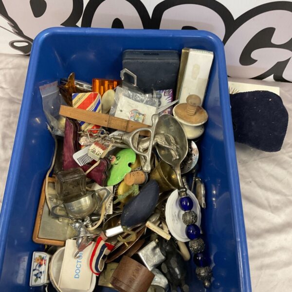 Blue tub of mixed collectables including silver plated loving spoon and brass bell