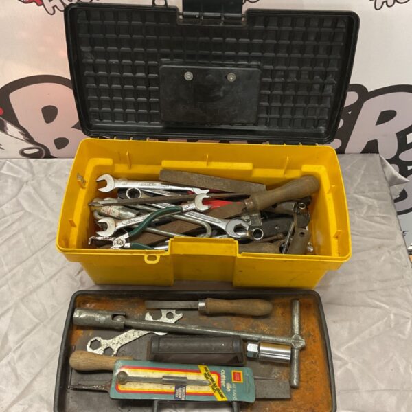 Yellow toolbox with mixed spanners, files and blades on display