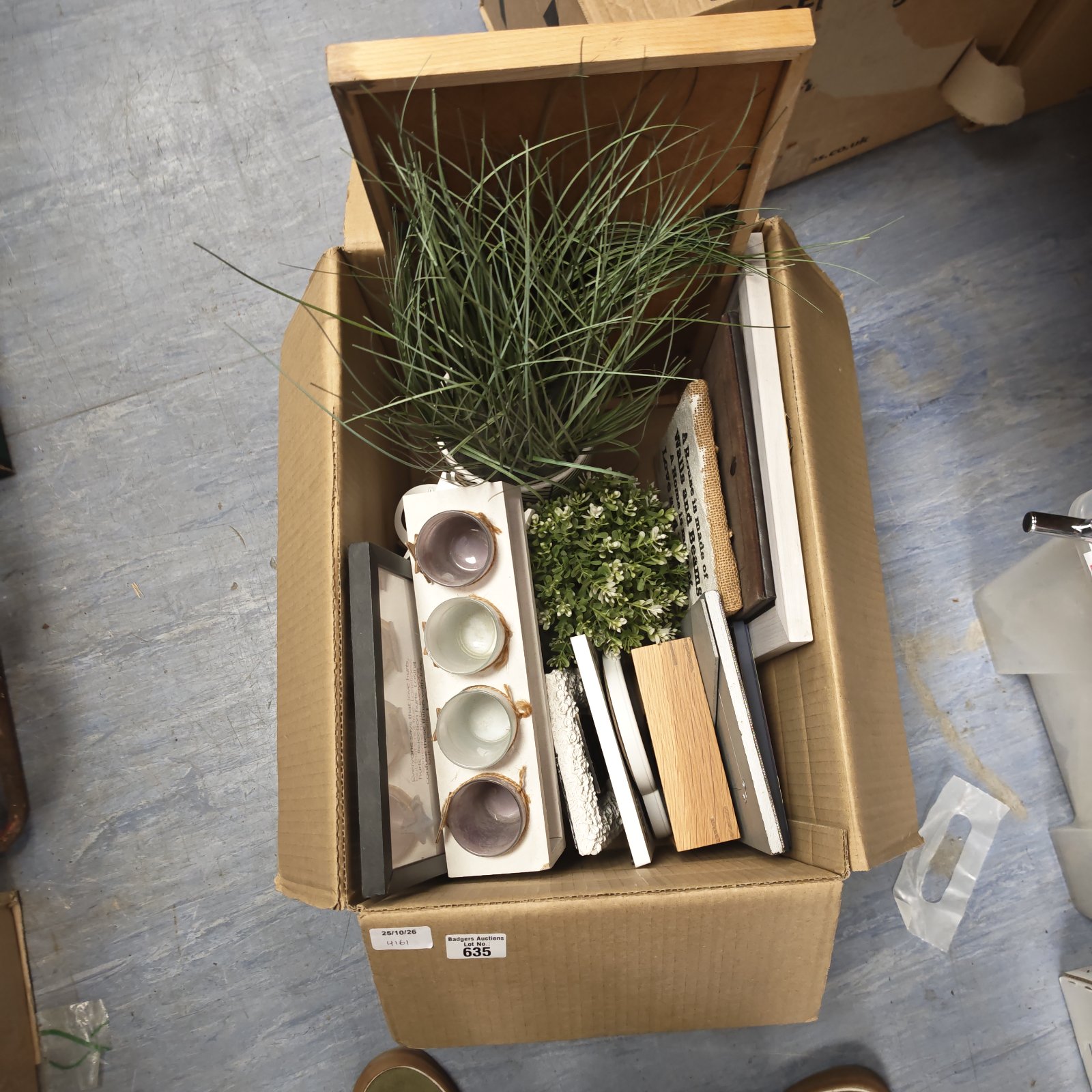 Box of mixed homewear with faux potted plant, tea light holders and plaques