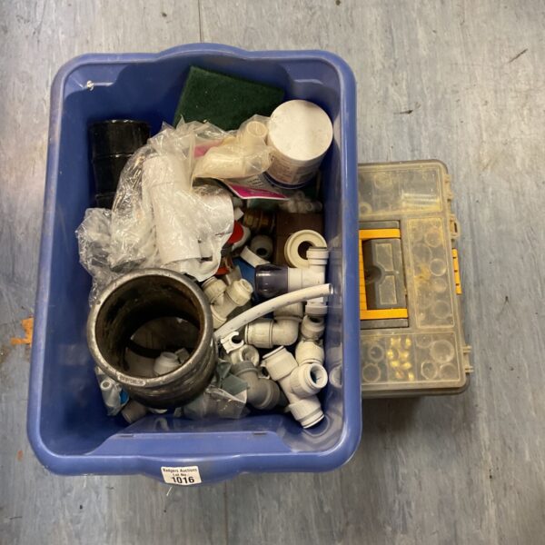 Blue tub of mixed plumbing push-fit connectors beside a toolbox of nuts and bolts