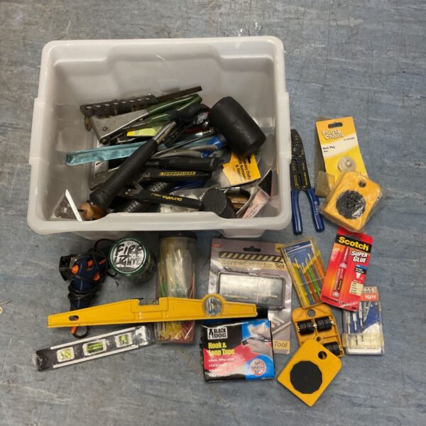 White crate of mixed hand tools, spirit levels and DIY accessories laid out
