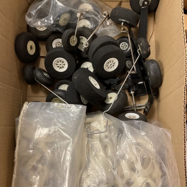 Box of model aircraft tyres, wheels and undercarriage legs with rubber bands