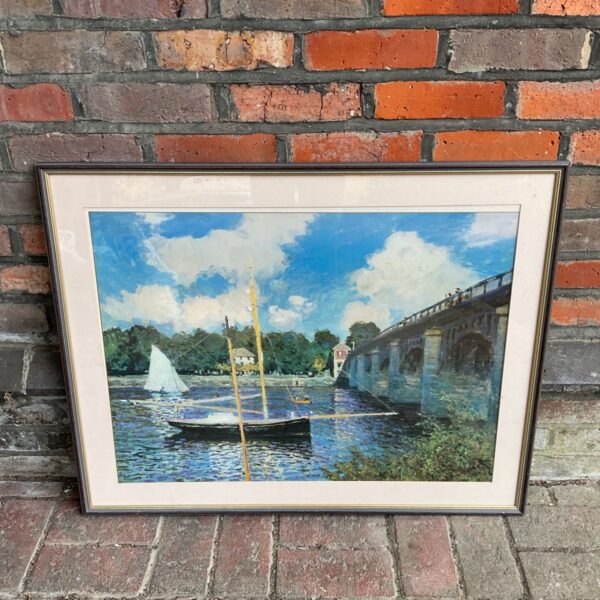Framed Claude Monet print of Argenteuil bridge and sailboat landscape.