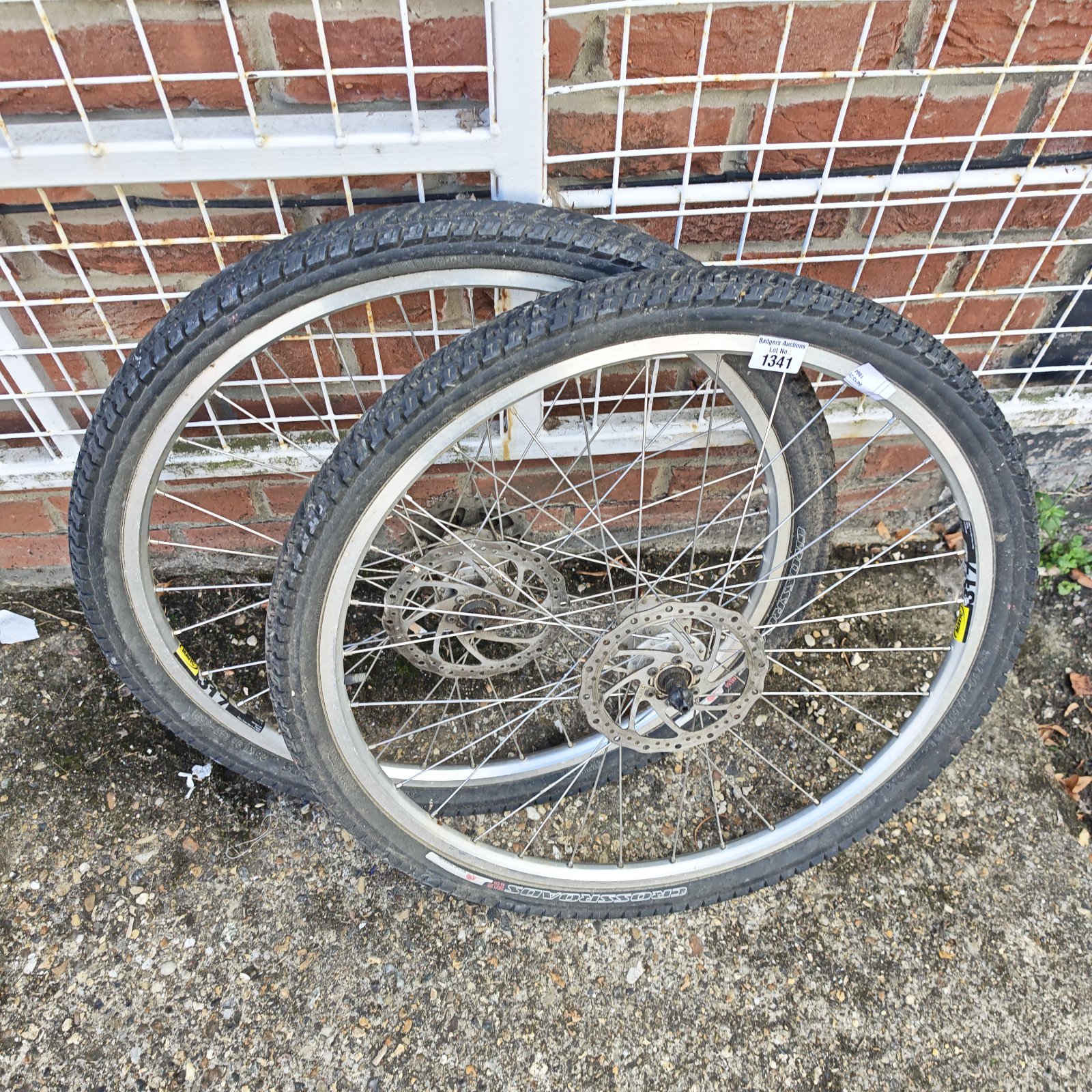 Silver mountain bike wheels with crossroads tyres for off-road cycling.