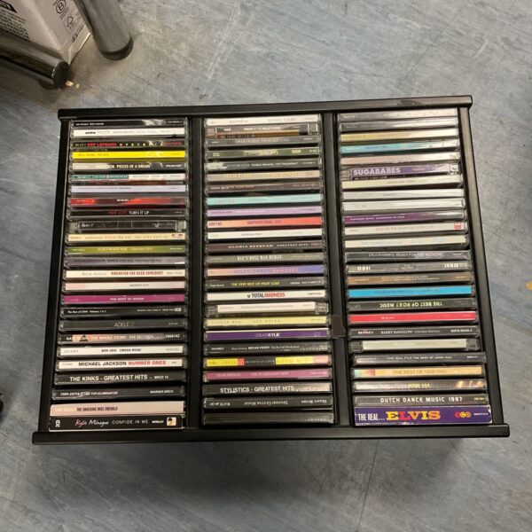 Black CD storage tray filled with music CDs including Elvis, The Kinks and Michael Jackson