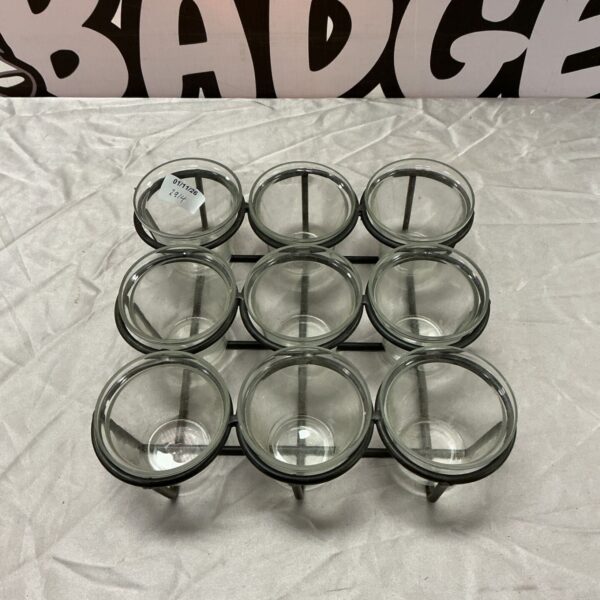 Nine clear glass tealight holders in a dark metal frame, arranged in a grid