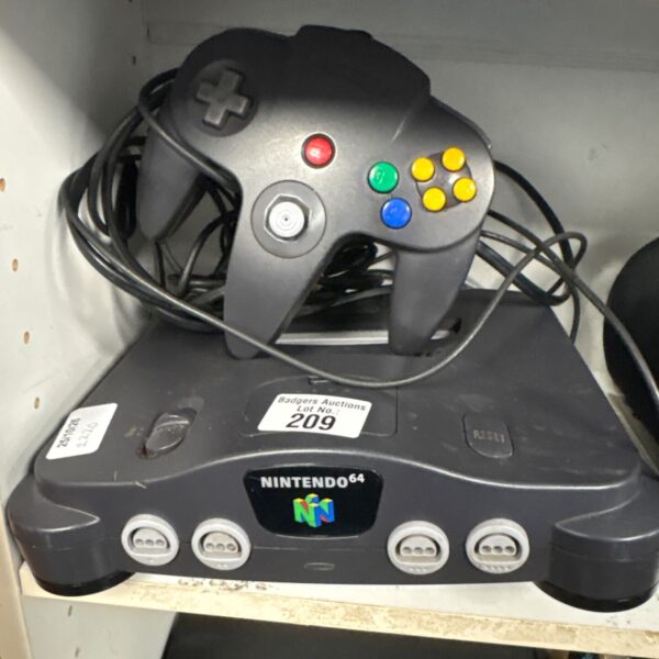 Grey Nintendo 64 console with black controller and cables on shelf