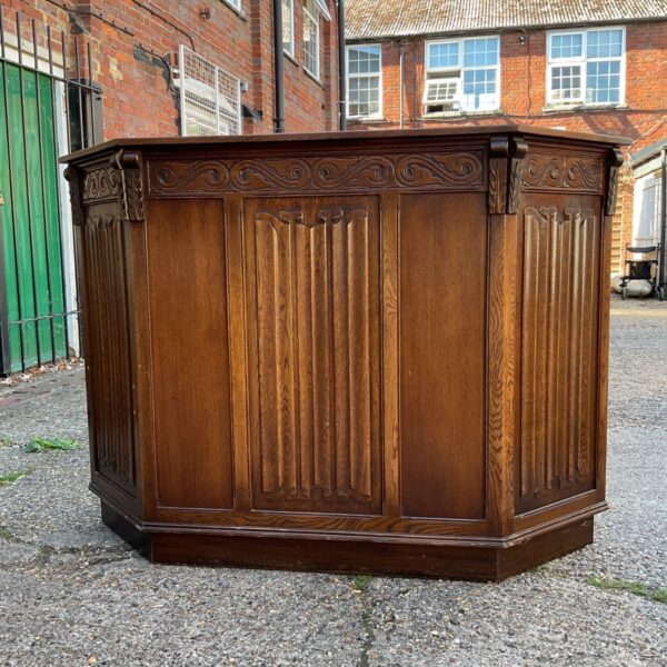 Vintage oak bar unit with scroll design in a home setting.