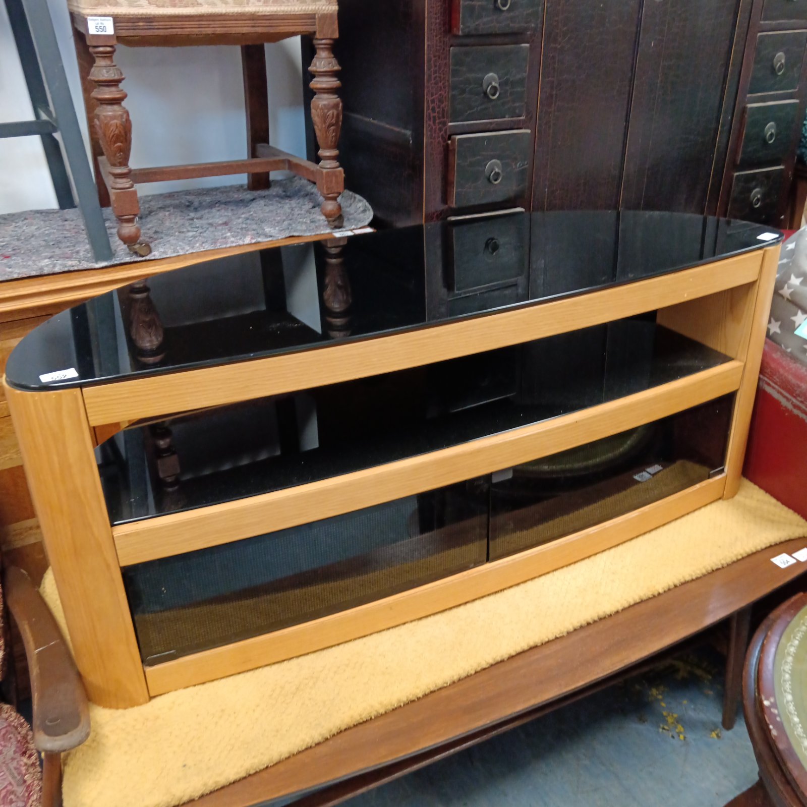 Modern oak media cabinet with black glass front for home entertainment.