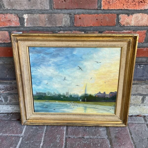 Vintage oil painting of a cathedral skyline in a gilt frame.