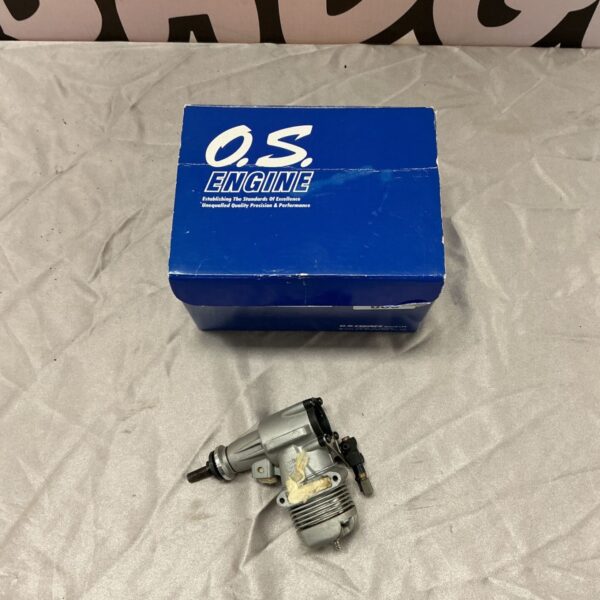 OS 40/46LA glow plug engine displayed beside its blue O.S. Engine box
