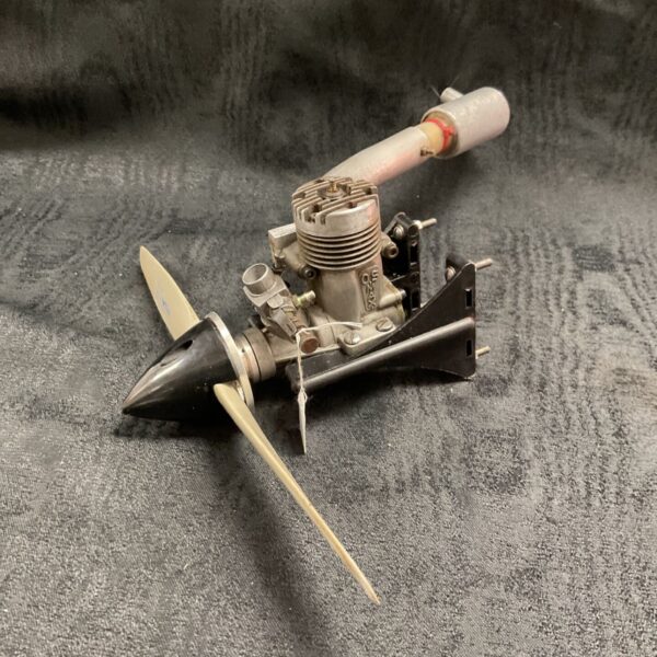 OS max25 model engine with silencer on mount frame, front angle
