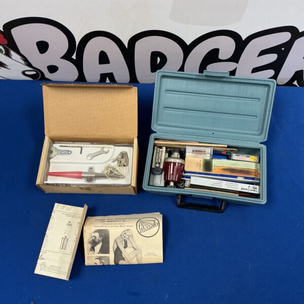 Paasche airbrush kit in box beside teal case of stationery
