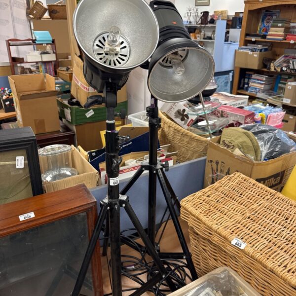 Pair of floor standing studio lights with silver reflectors on black tripod stands