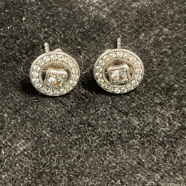 Close-up of sparkling Pandora silver stud earrings.
