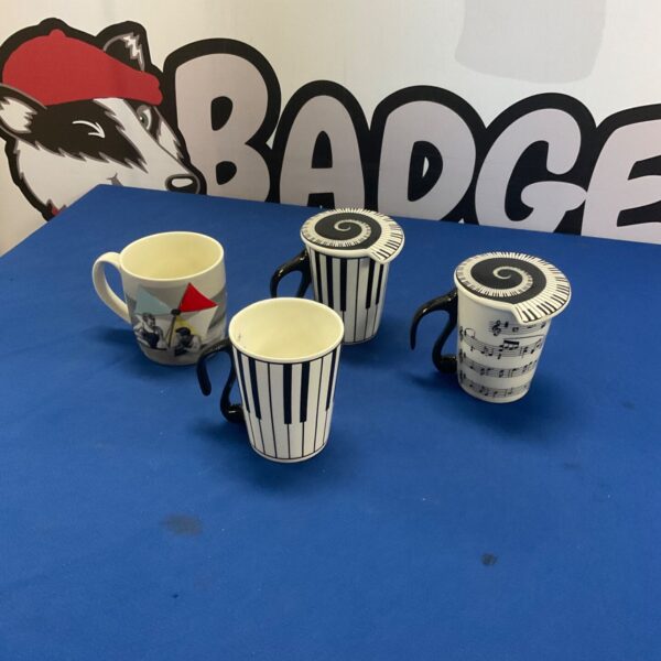 Two piano key mugs with lids, a unique kitchen collectible.
