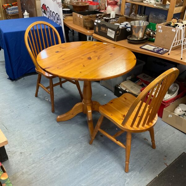 Vintage pine folding table with two chairs in a kitchen setting.