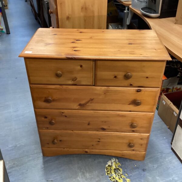 Pine two over three chest of drawers with turned wooden knobs and plinth base