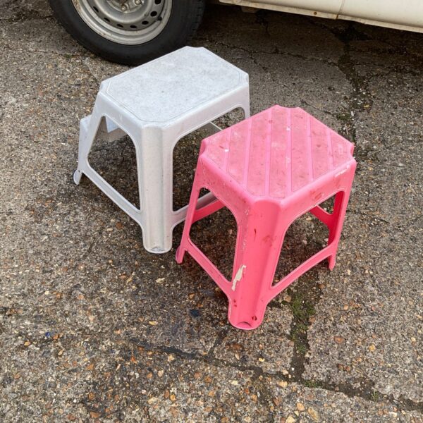 Two plastic kitchen steps in a garden setting.