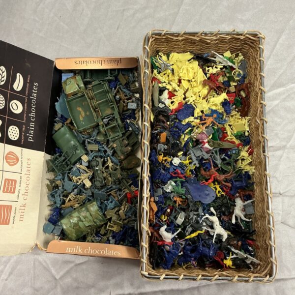 Mixed collection of plastic model soldiers and miniature military figures in boxes and basket