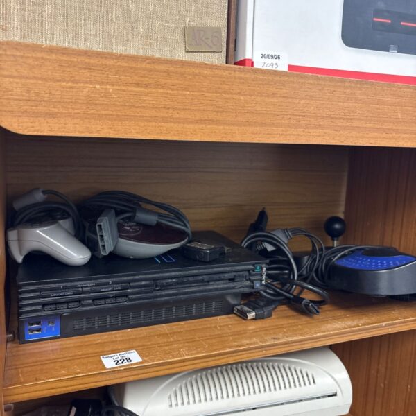Slimline Sony PlayStation 2 console with accessories.