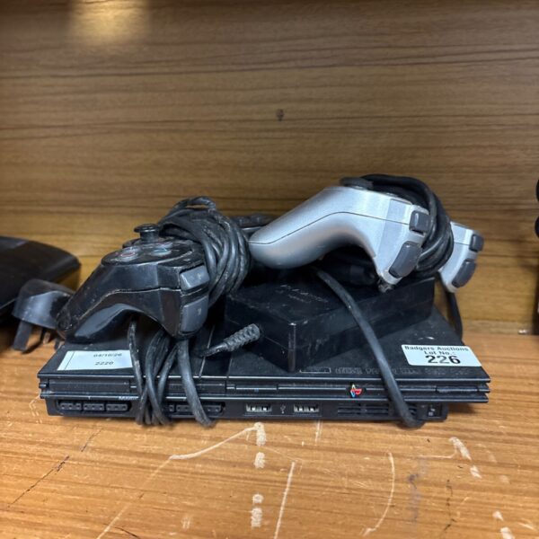 Sony PlayStation 2 slim console with controllers and power supply.