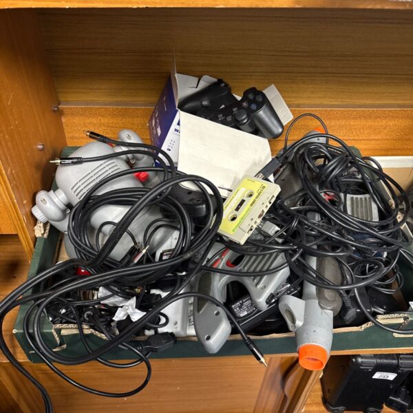 Gaming console lot with PlayStation, controllers, and cables.