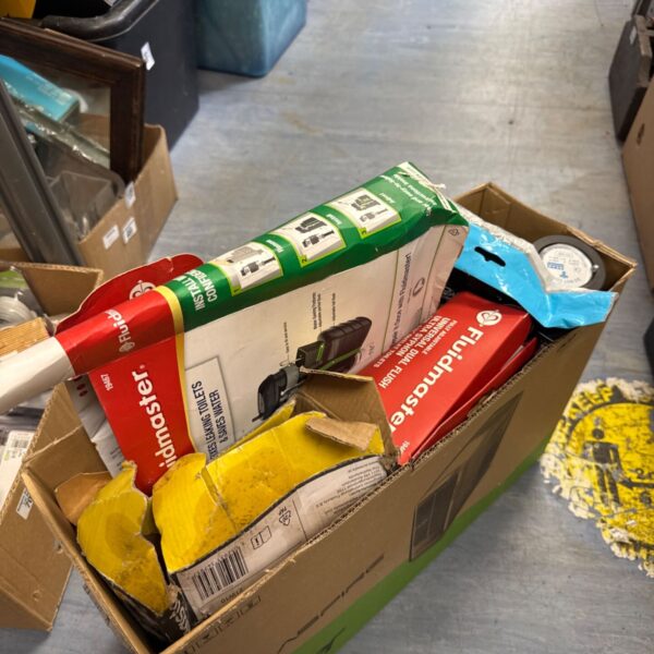 Box of assorted plumbing parts including Fluidmaster flush valves.