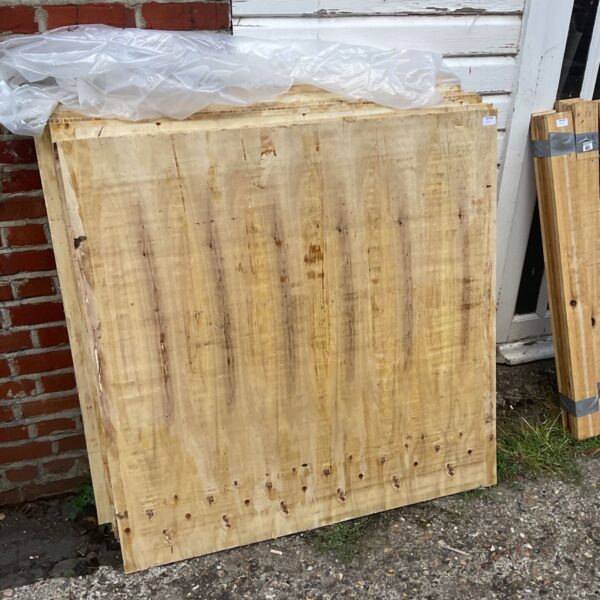 Stack of 4x4 plywood sheets for construction projects.
