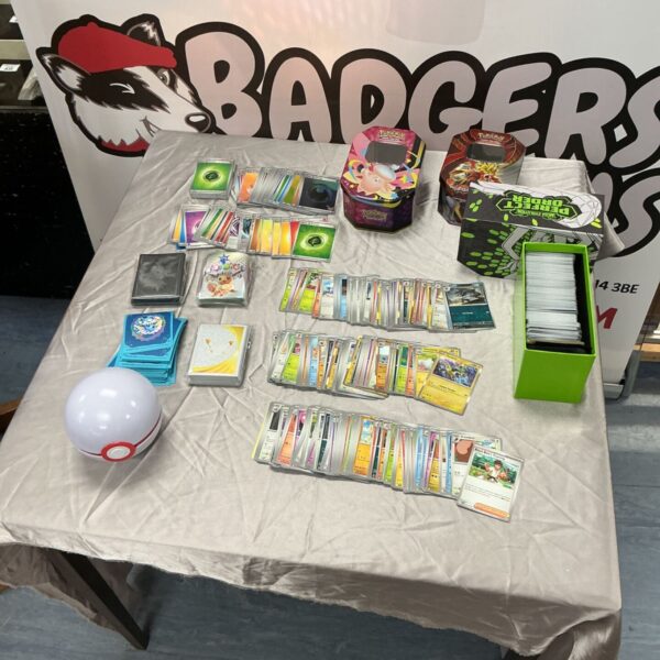 Large Pokémon trading card lot with collector tins and storage box on table