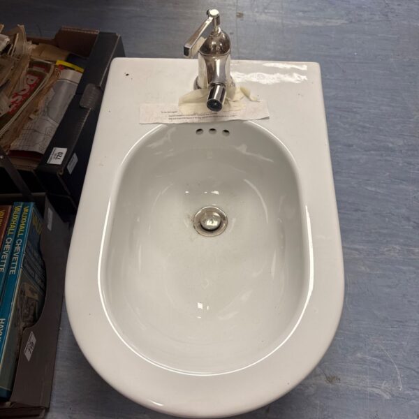 White porcelain bidet with tap, vintage bathroom fixture.