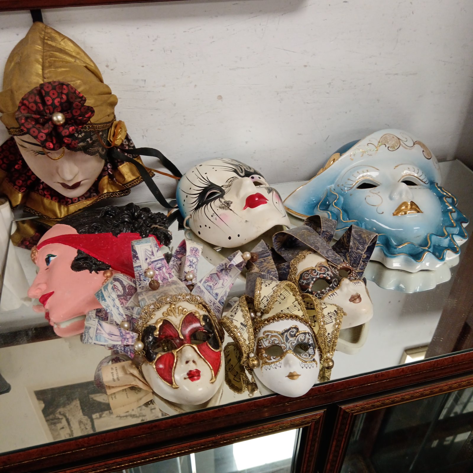 Collection of vintage porcelain masquerade masks displayed together.