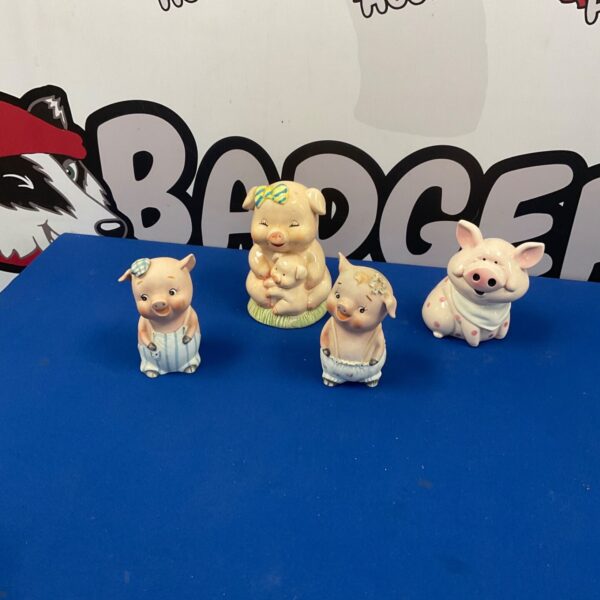 Vintage porcelain piggy banks with floral designs, collectible ceramic pigs.