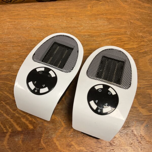 Pair of white portable plug-in wall heaters with mesh grilles and black controls