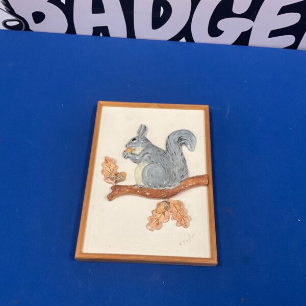 Handmade pottery squirrel relief plaque, charming animal wall decor.