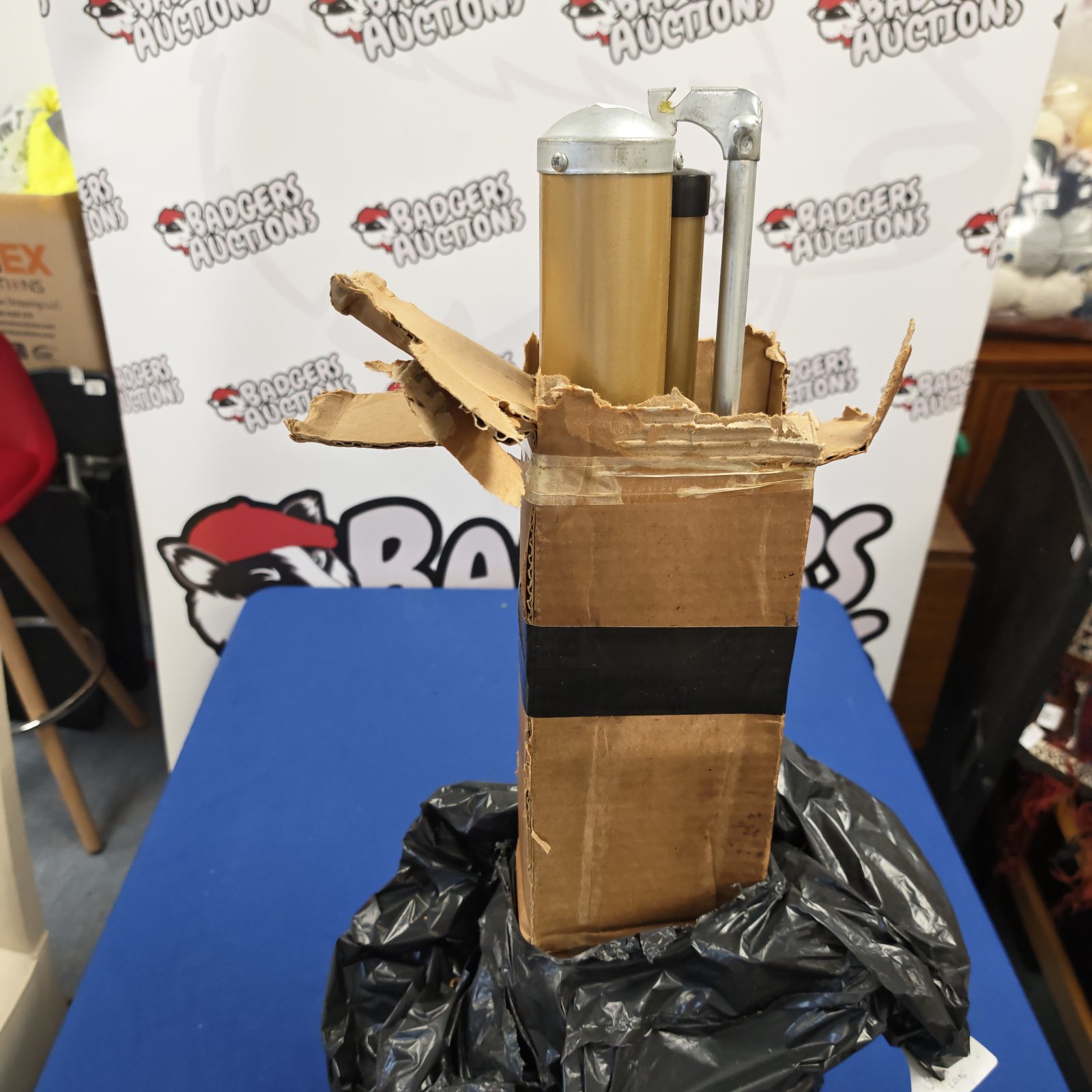 Projector screen casings and bracket emerging from open cardboard box