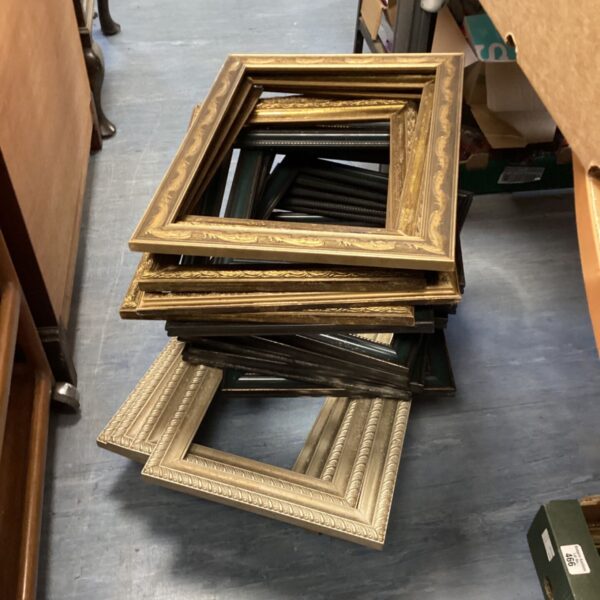 Stack of empty ornate gilt and black picture frames in mixed sizes