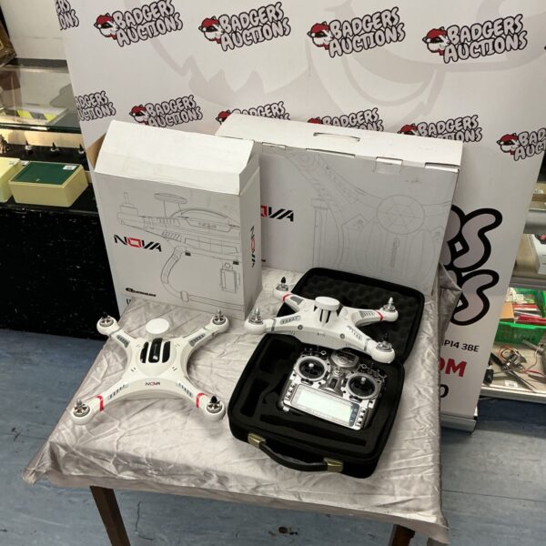 Two white Quanum Nova drones beside a Taranisx9d transmitter in case