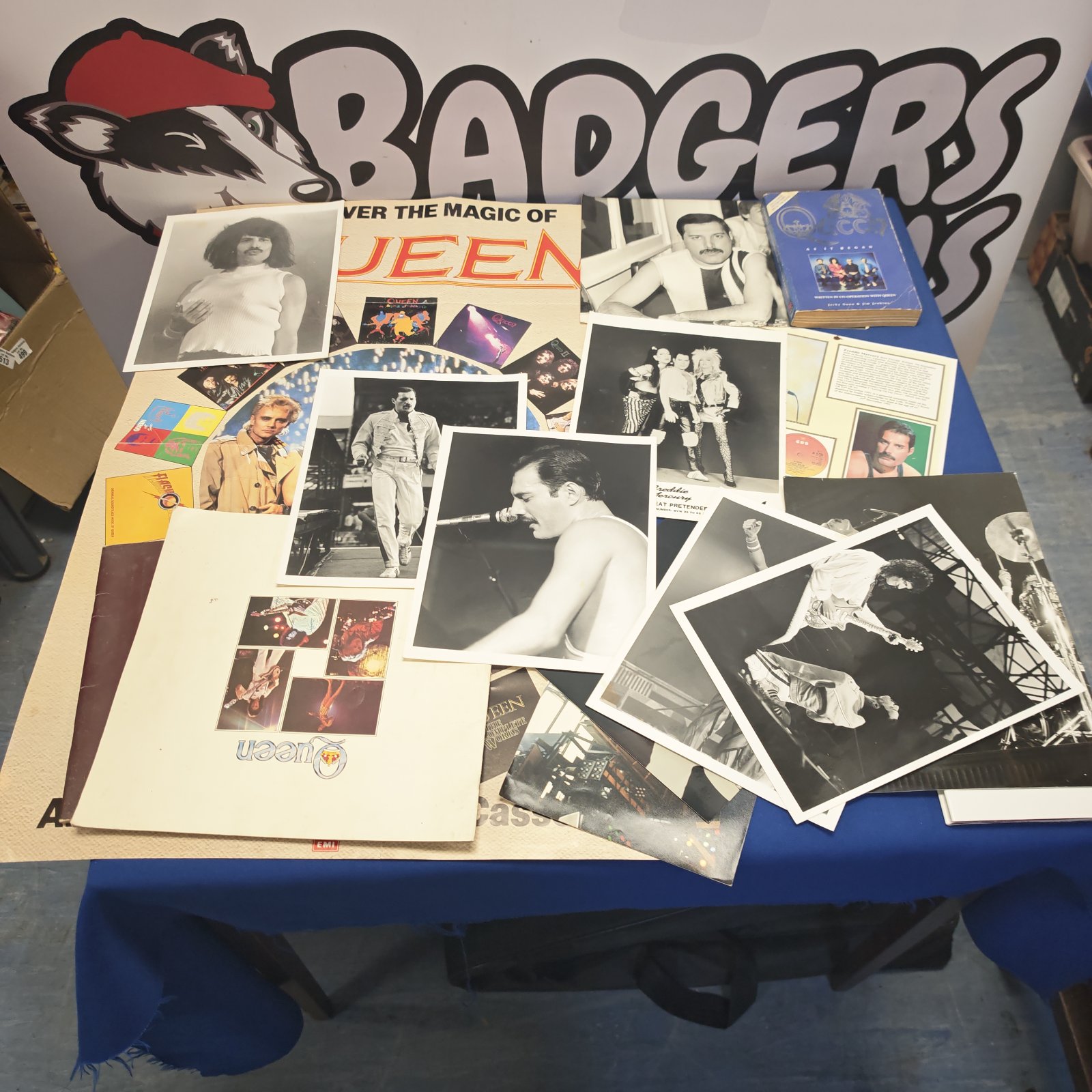 Queen memorabilia lot featuring posters, photos, and a book.