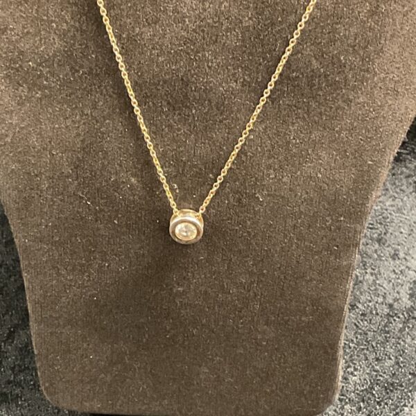 Close-up of Radley silver necklace with stone pendant on display.