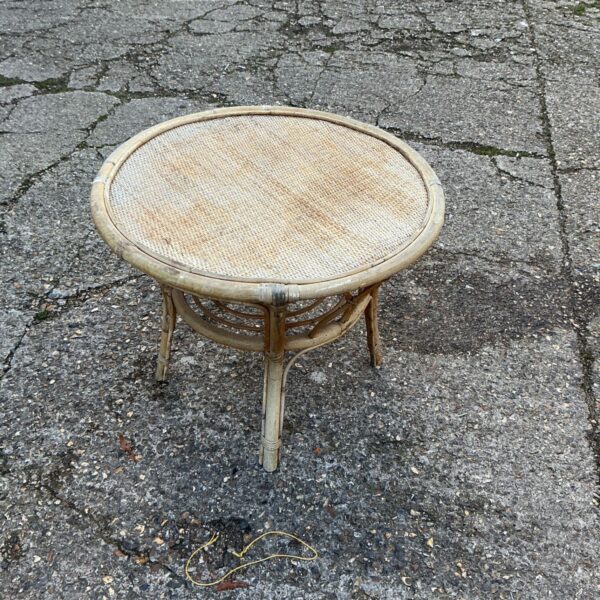 Small round rattan patio table with woven top and lower stretcher ring