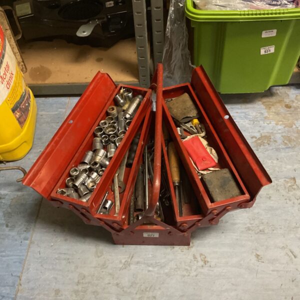 Red cantilever tool box with sockets, wrenches and hand tools inside.