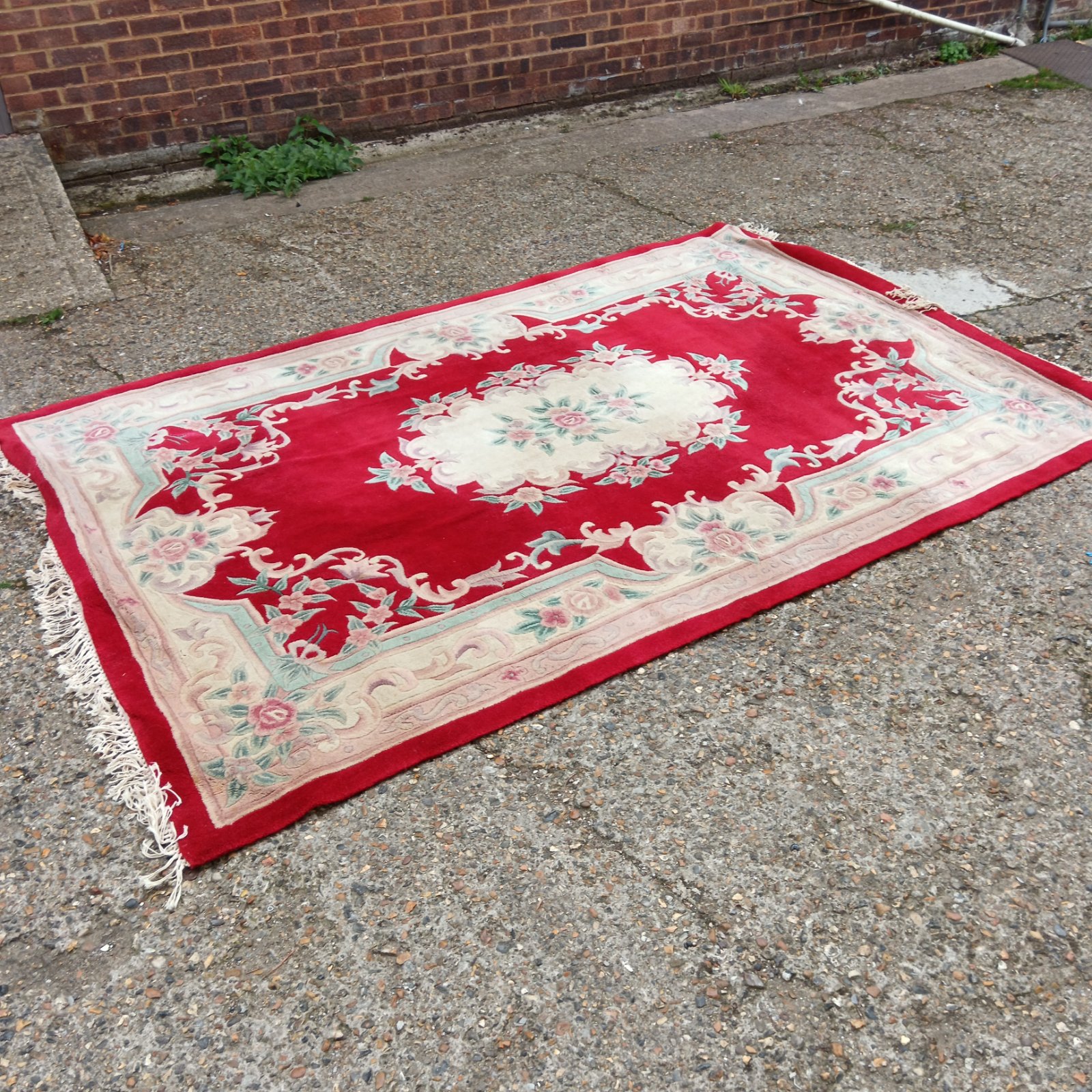 Large red floral wool rug with detailed pattern.