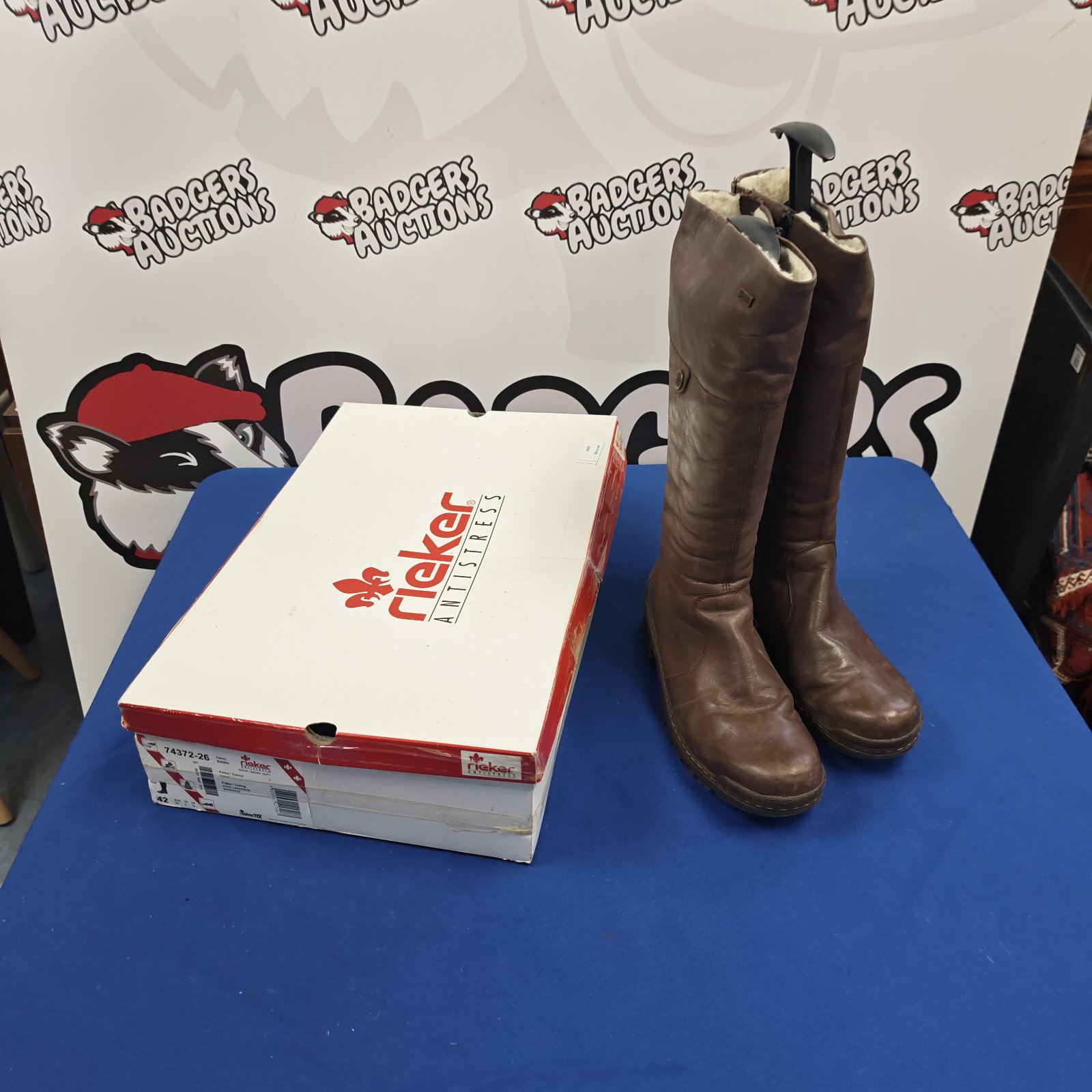 Brown leather Rieker Antistress knee-high boots beside original box