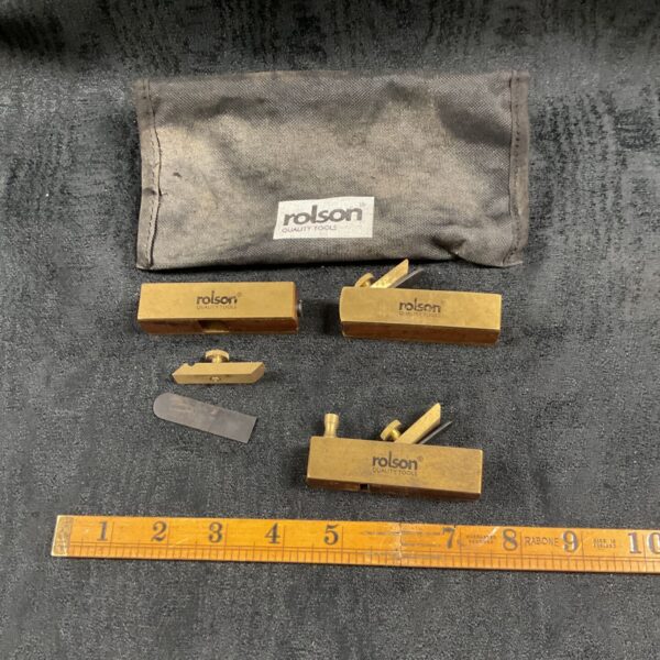 Three miniature Rolson wood planes with brass bodies beside a Rolson pouch
