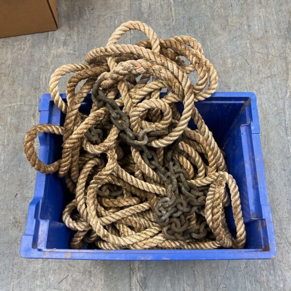 Coiled natural fibre rope and dark link chain in blue plastic crate