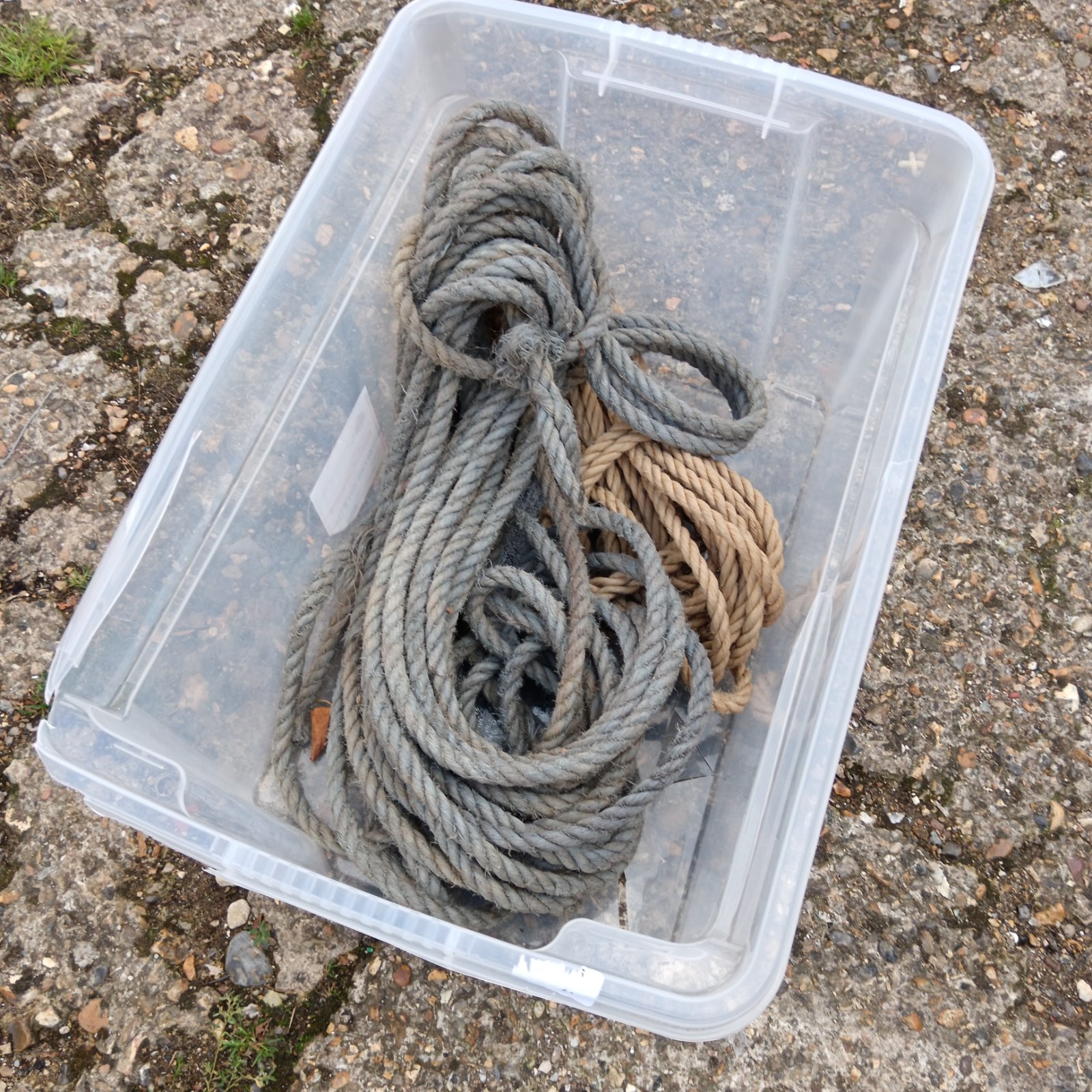 Two lengths of vintage rope in a clear plastic box.