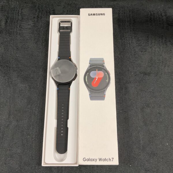 Samsung Galaxy Watch 7 with black band beside its white retail box
