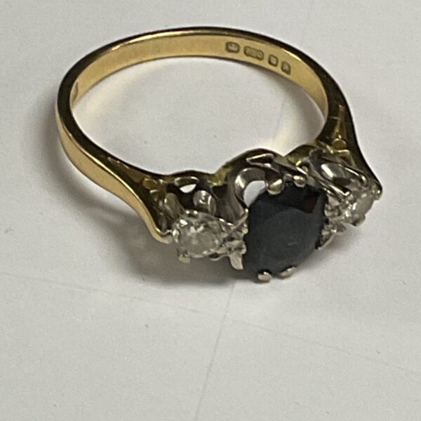 Gold ring with a large sapphire and diamond stones.